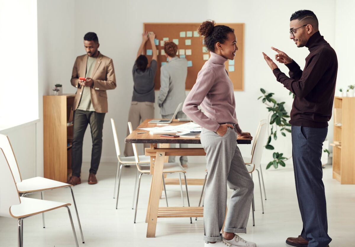 : three women engaging in small talk while working with documents